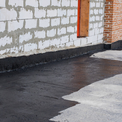 flat roof coating being applied on a commercial roof